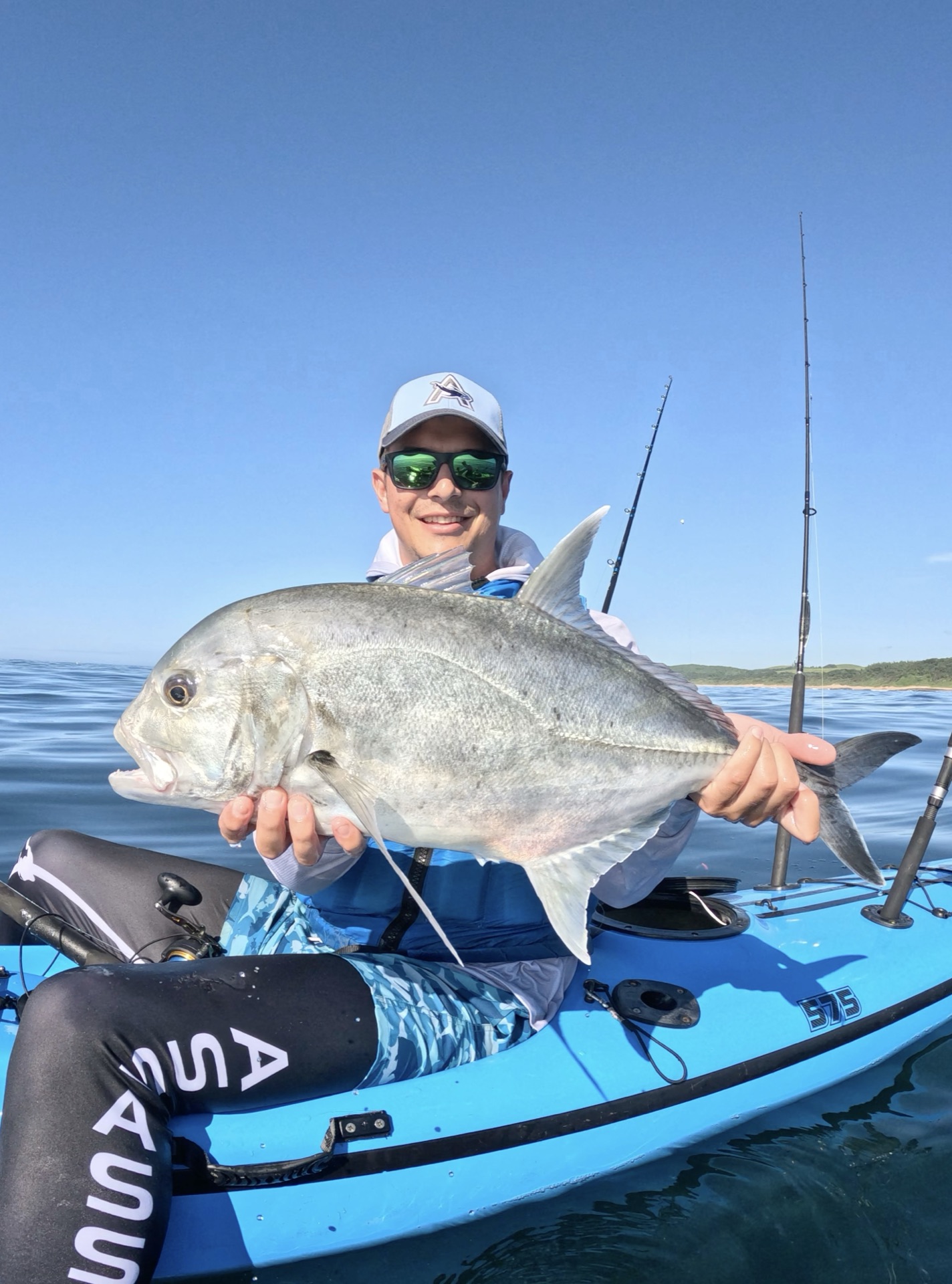 Francois Van Der Merwe holding a kingfish on his kayak