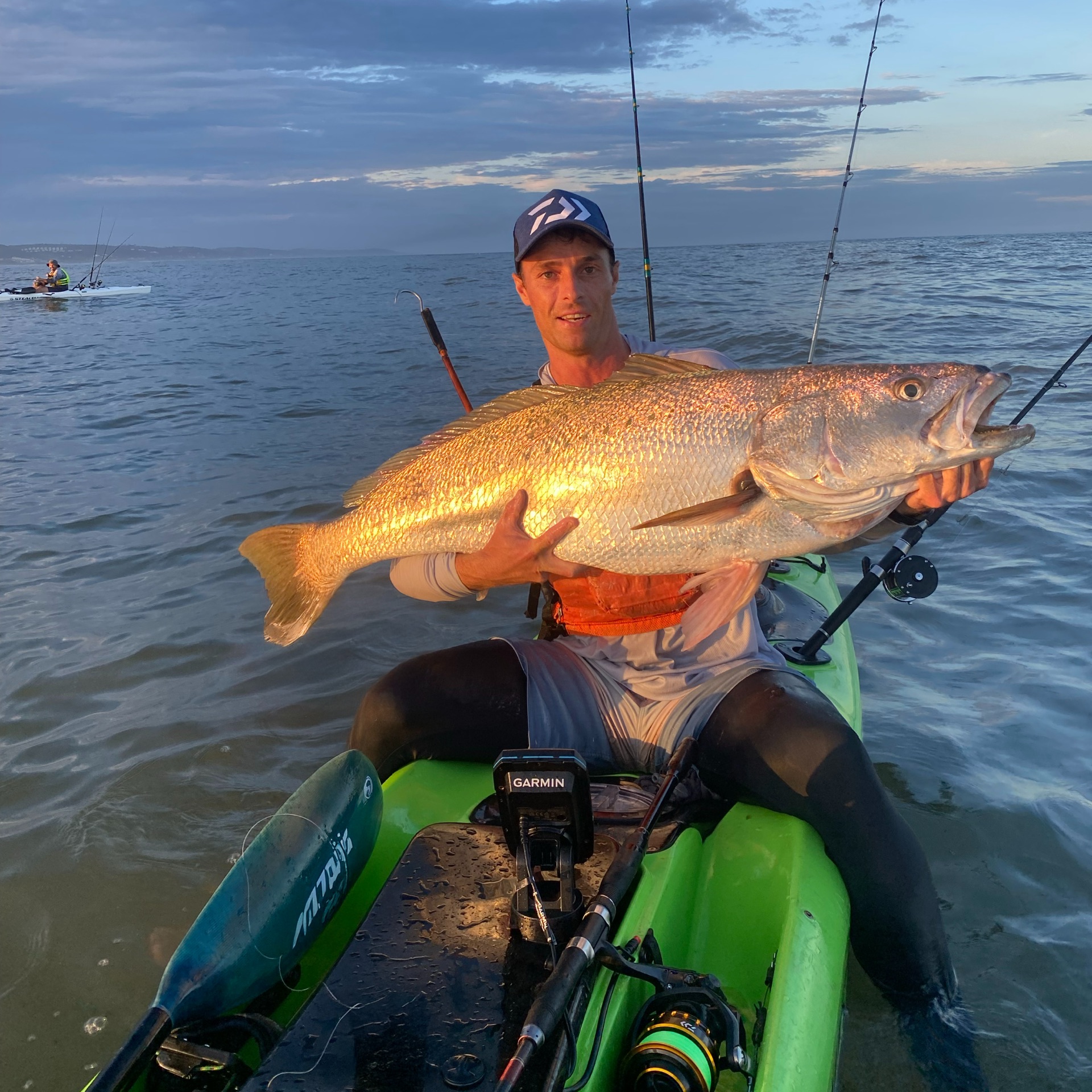 Salt Rockers crew member on a Stealth Fusion kayak holding a big catch